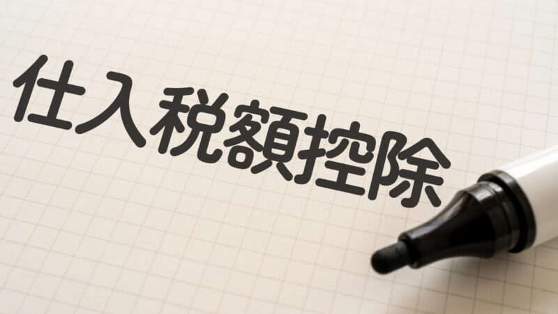 仕入税額控除の文字が方眼用紙に太字で書かれているイメージ。右下に黒いマーカーが置かれている。