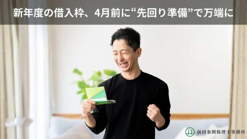 笑顔の男性が通帳を手にし、新年度の借入準備をイメージさせるブログのアイキャッチ画像